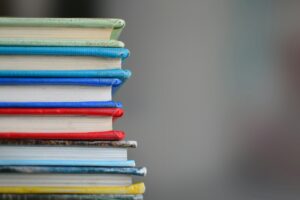 A colorful stack of books for back-to-school shopping while dealing with inflation